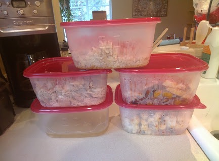 Stack of five medium sized transparent plastic containers of food. 