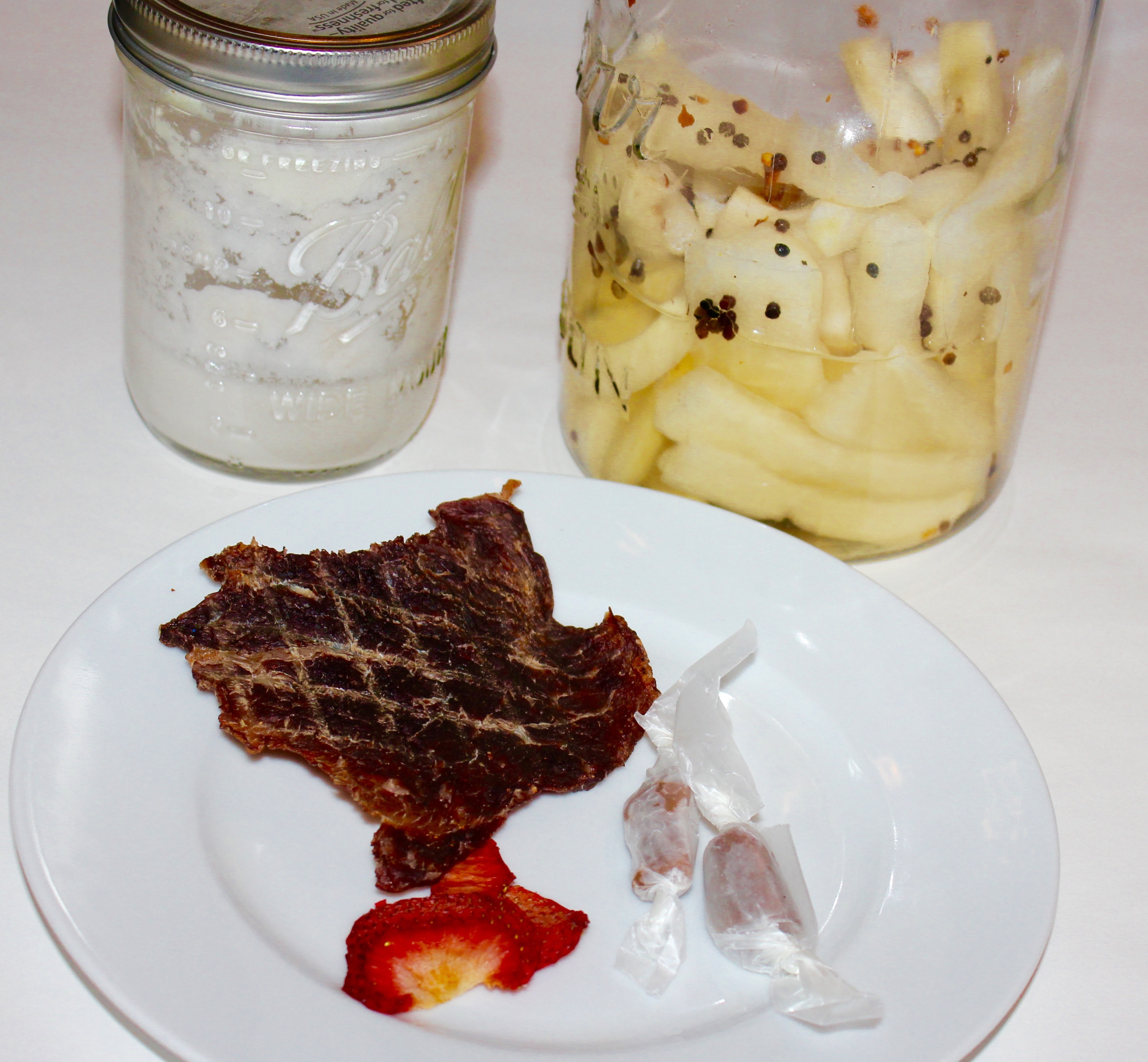 Because of moderate and severe food allergies and intolerances, I have resorted to making foods at home from scratch or in single-ingredient form. Picture from left to right: pure coconut milk, pickled daikon; plate, contains beef jerky, vegan salted lavender, caramels, dehydrated strawberry slices.