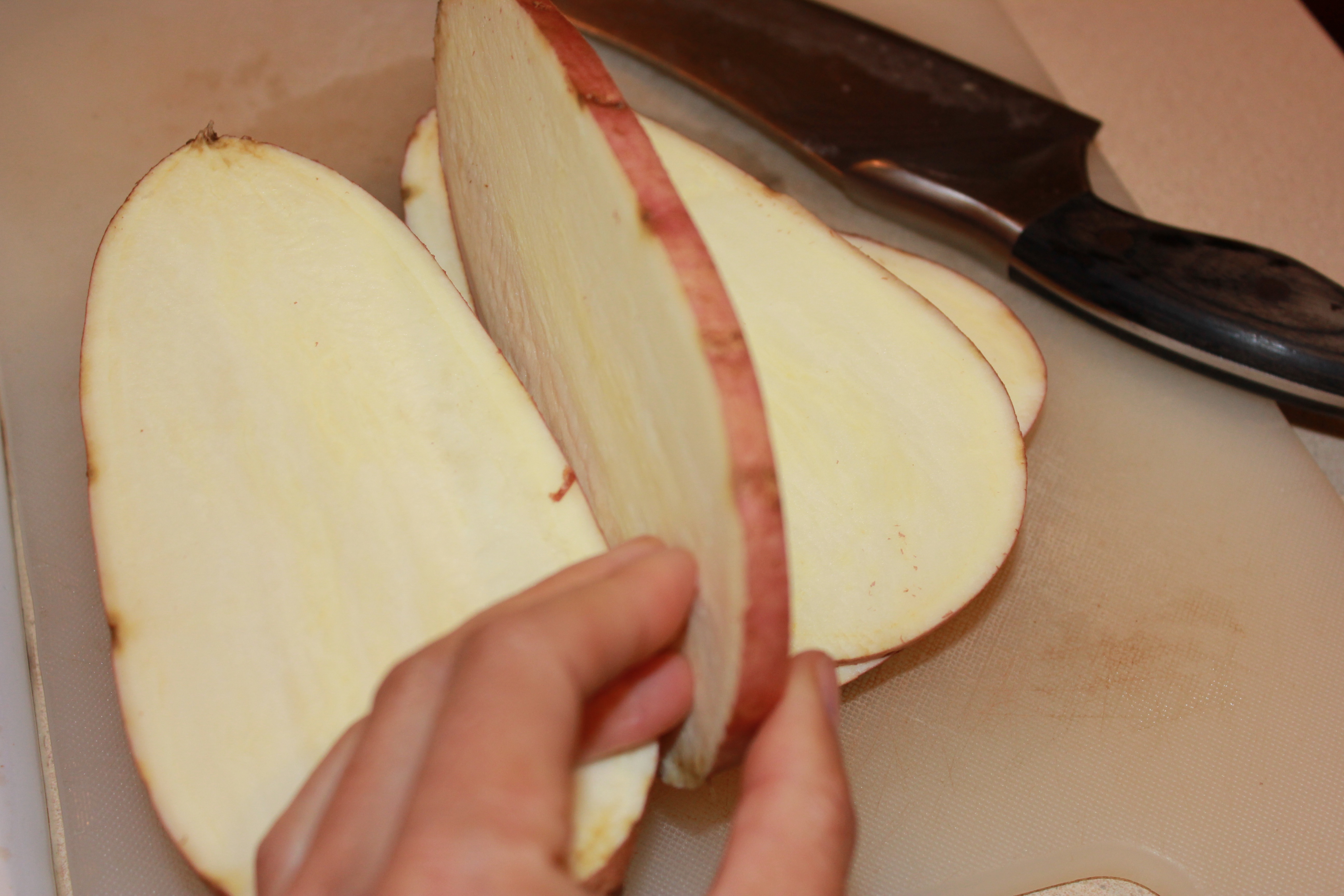 Slicing a yellow-fleshed sweet potato. I selected this one because it has larger, rounder surface to pile my ingredients