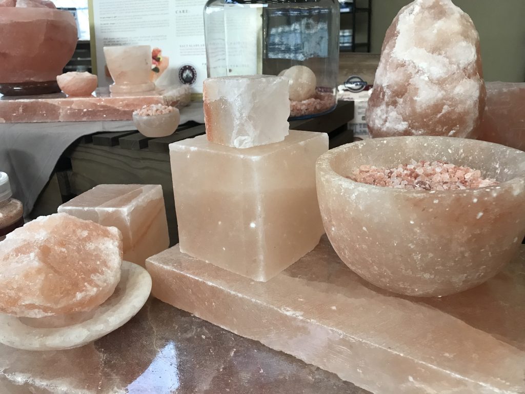 Blocks, rounds, bowls made of Himalayan Pink Salt, on an island counter in a showroom. 